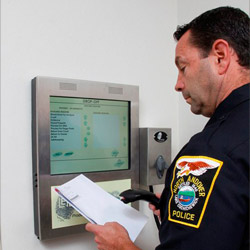 Officer Managing Evidence with Wall Mounted Kiosk