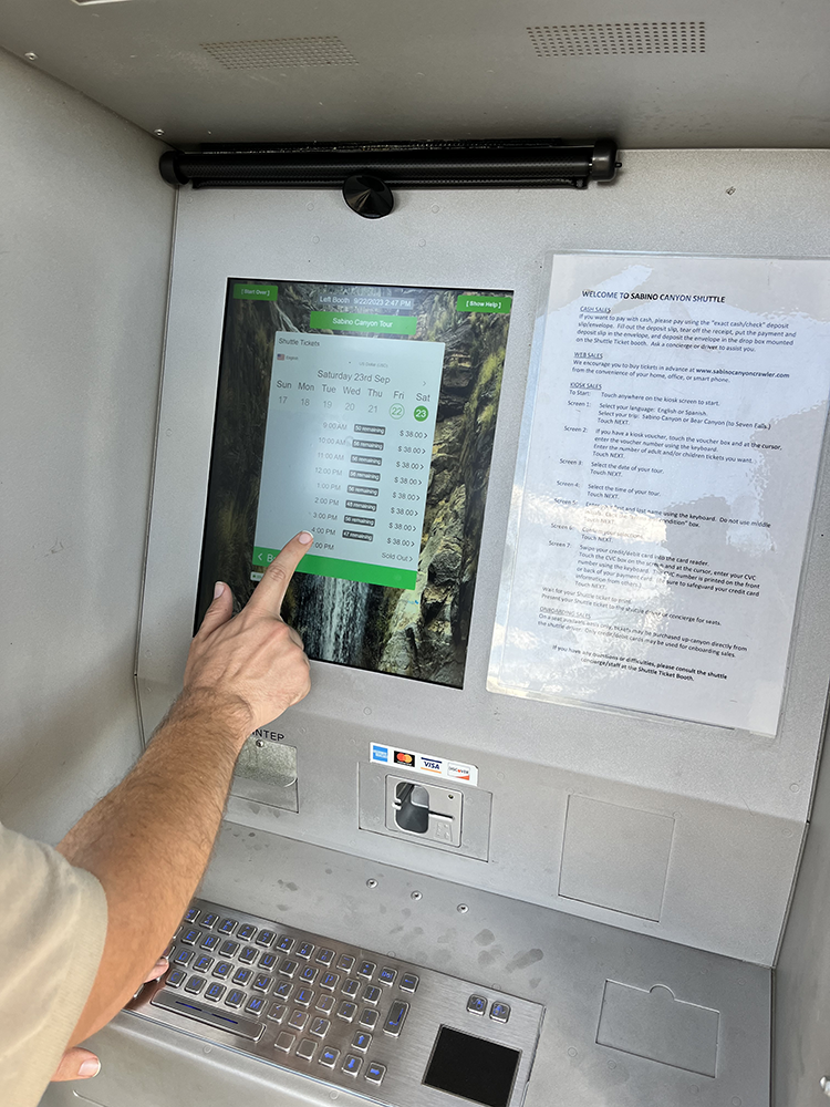 Customer buying tickets on thru-wall kiosk