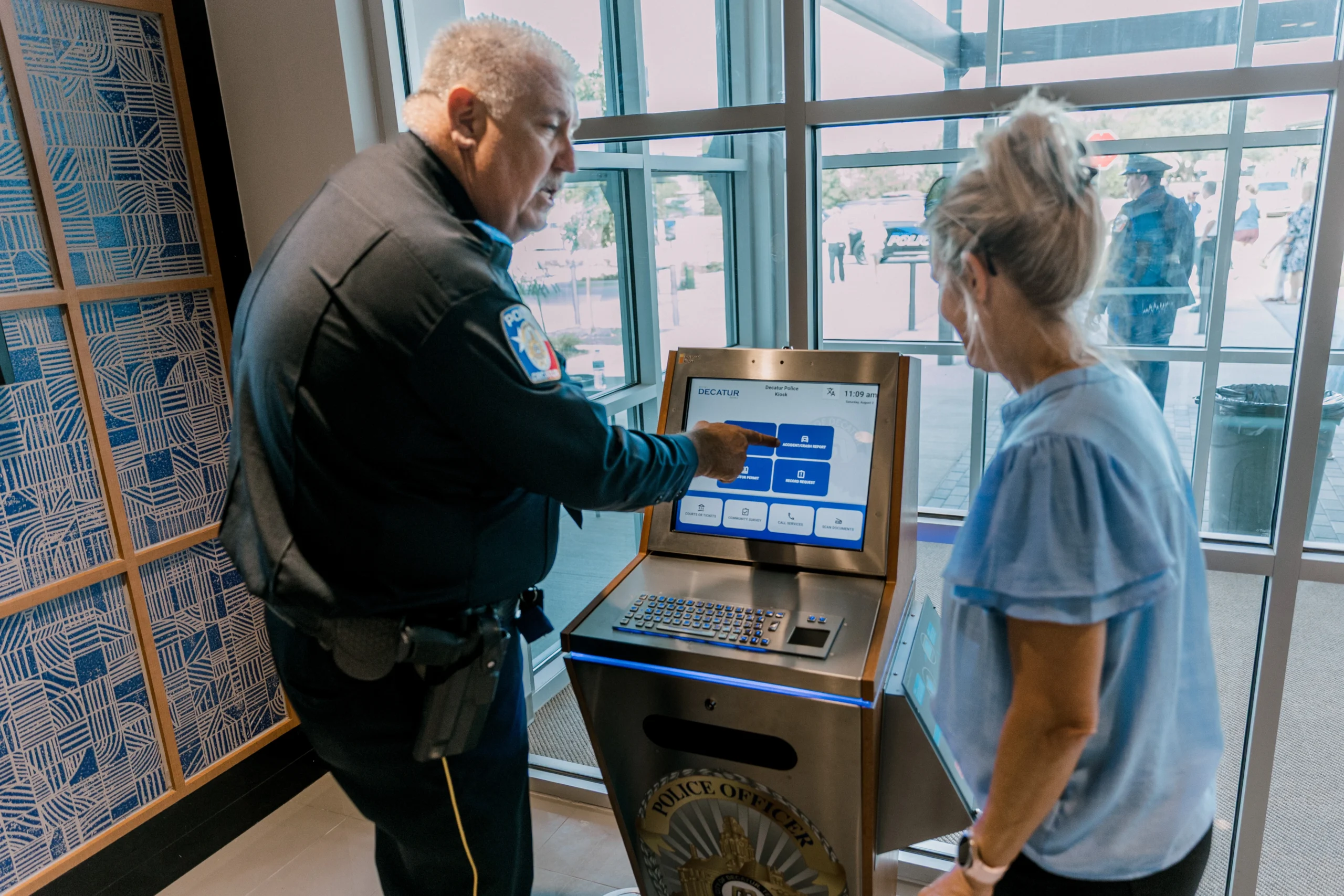 Police officer instructing kiosk user